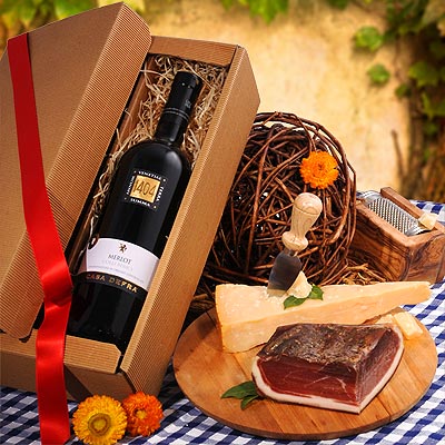 Geschenkidee Merlot Ein Geschenkset mit Merlot, Speck und Hartkäse.