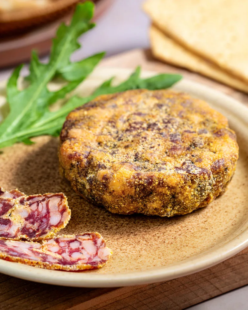 Runde Salami vom schwarzen Schwein - Bio – mit passenden Accessoires arrangiert