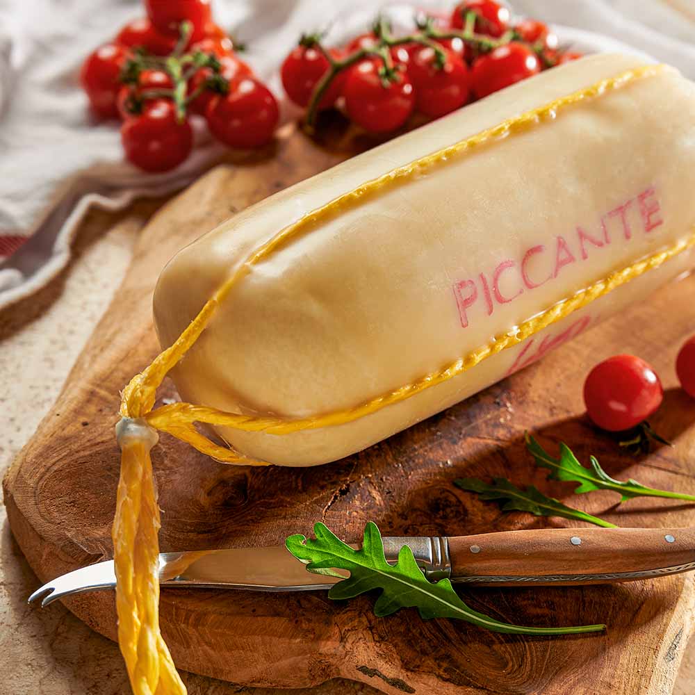 Gereifter Provolone – ganzer Laib – mit passenden Accessoires arrangiert