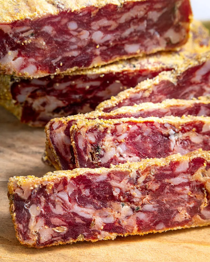 Runde Salami vom schwarzen Schwein - Bio – mit passenden Accessoires arrangiert