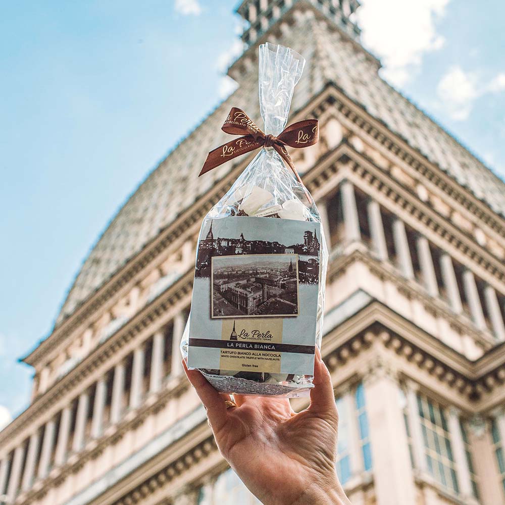 Tartufi - Haselnuss und weiße Schokolade – serviert auf einem Teller, mit Schokoladenstücken